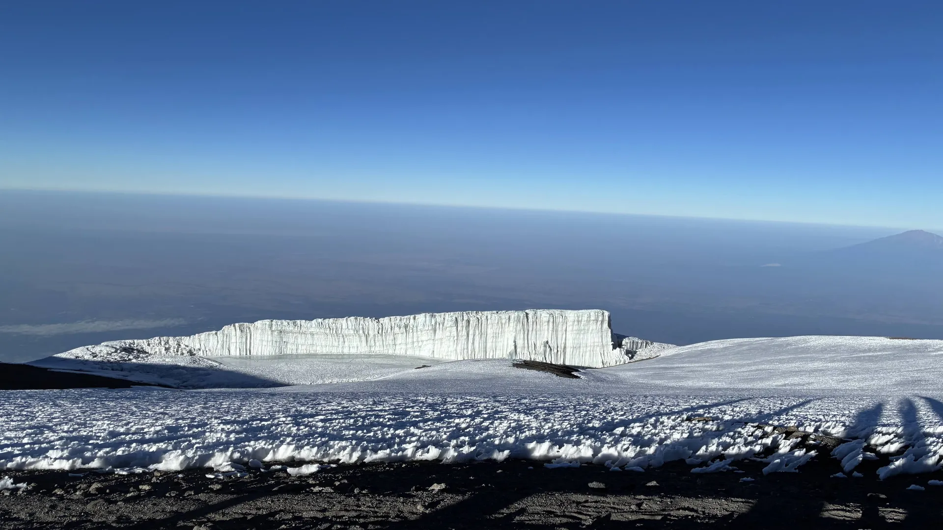山頂近くの雪原と、切り立った氷河の壁